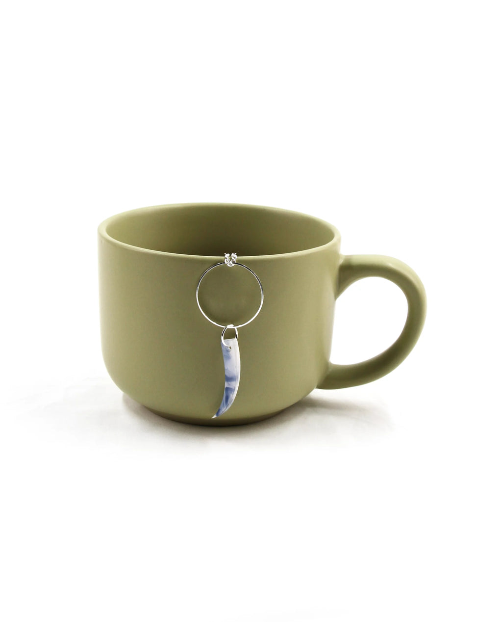 Collar Azur plateado presentado junto a taza decorativa