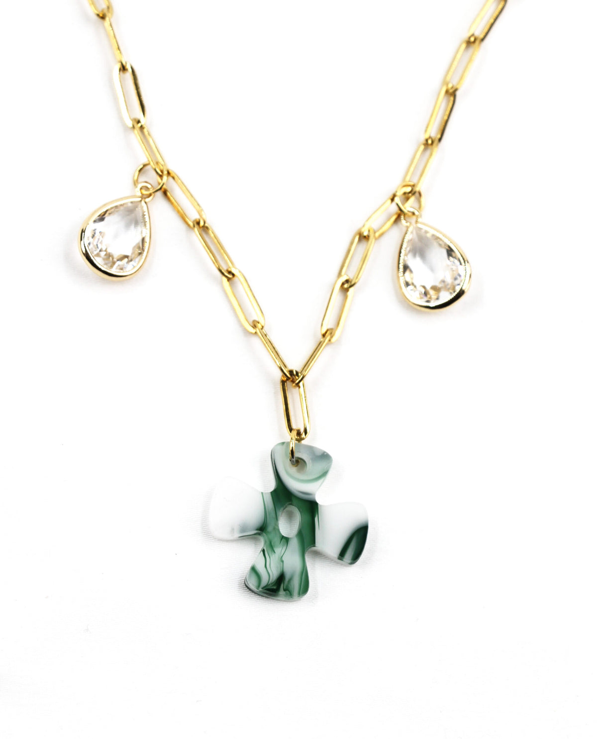 Detalle de la cruz verde del Collar Éden dorado