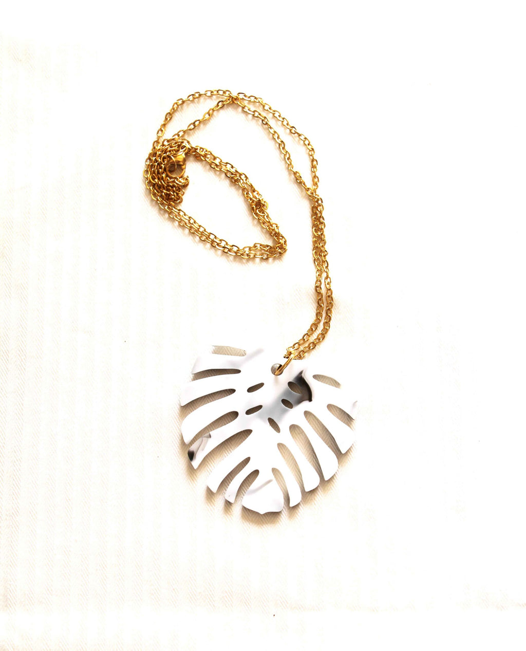 Detalle del Collar Monstera dorado con diseño de hoja