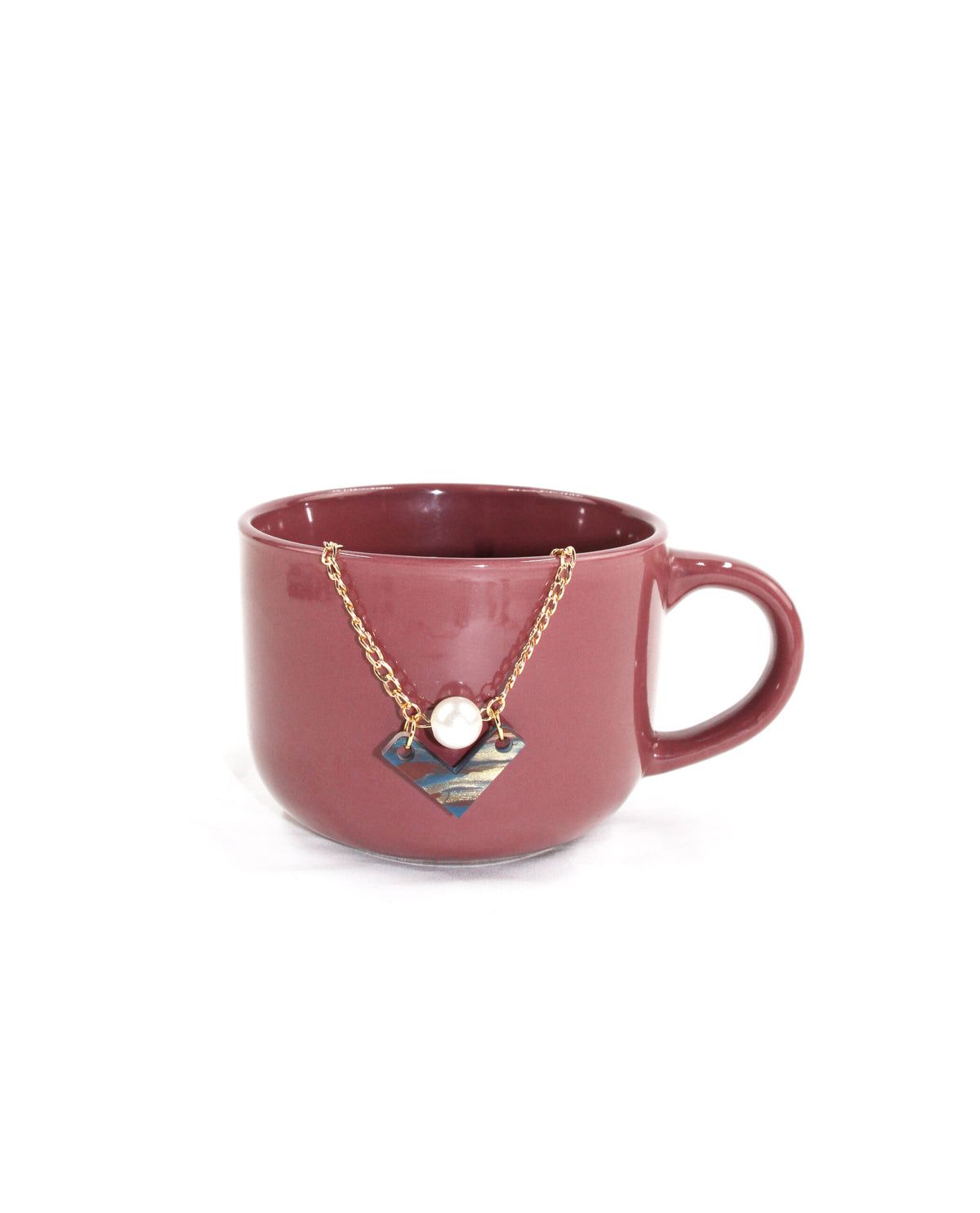 Collar Éclat dorado presentado con colgante geométrico decorativo