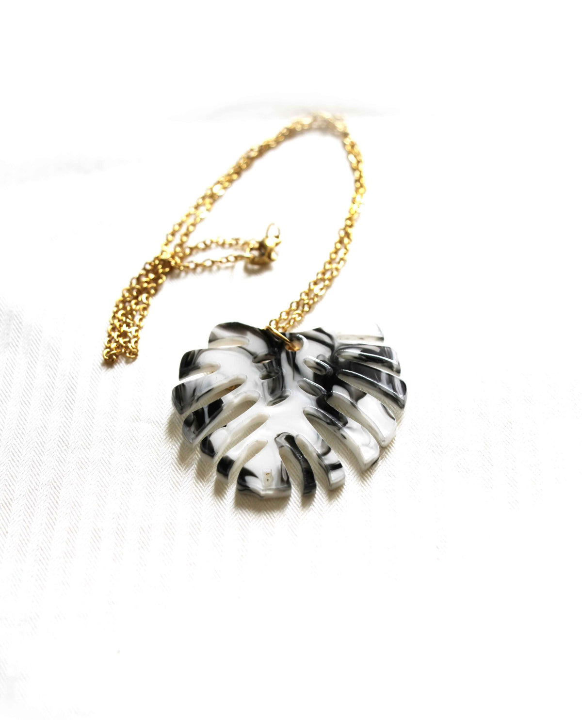 Collar con hoja Monstera decorada en blanco y negro