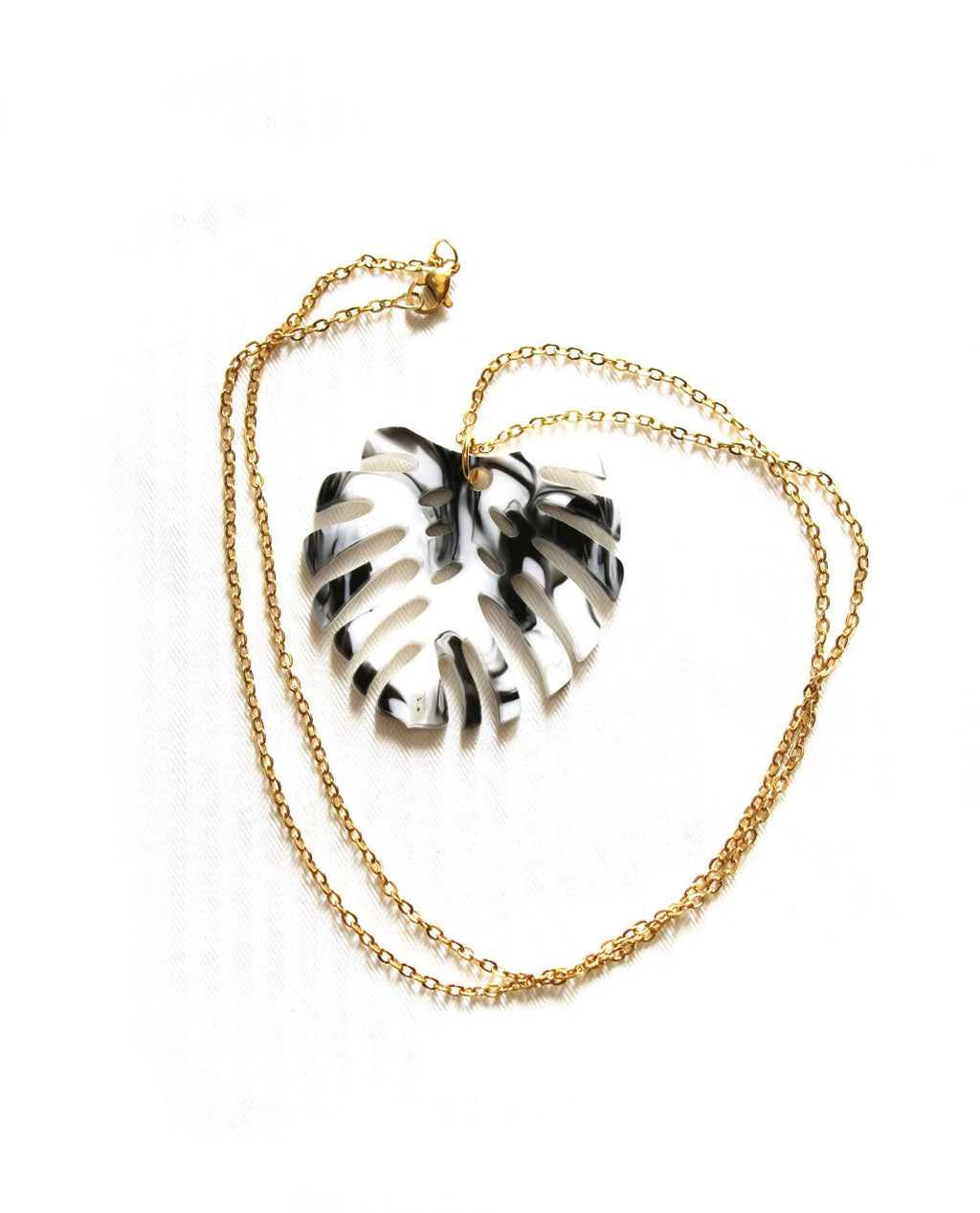 Colgante de hoja Monstera blanco y negro con cadena dorada