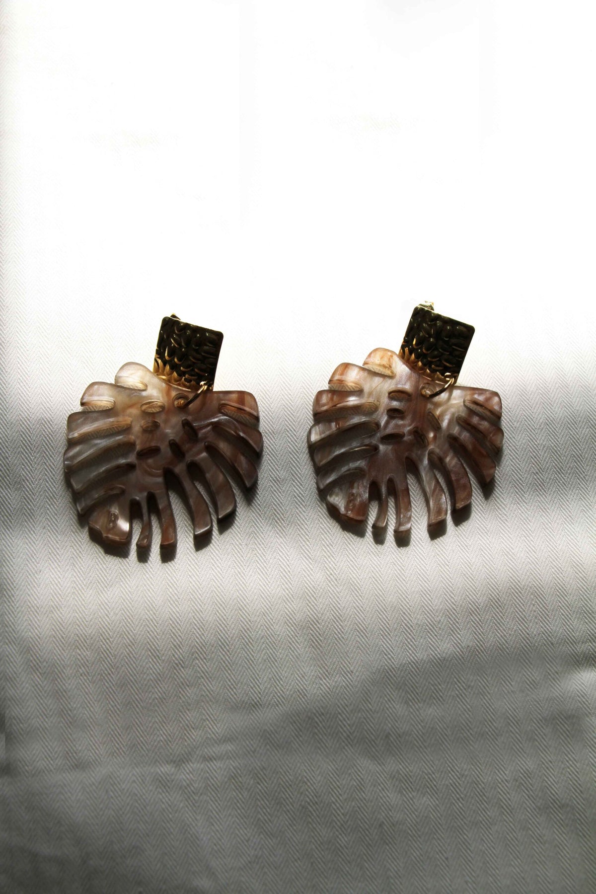 Detalle del efecto marmolado marrón de los Pendientes Monstera